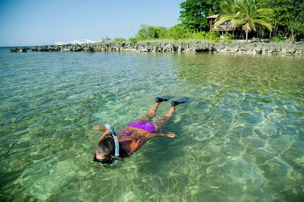 A snorkeler in the clear shallow water over the reef near West Bay, Roatan